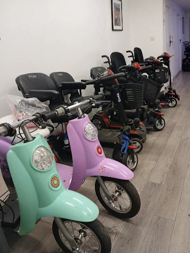 Mobility scooters and power wheelchairs lined up inside Electric Transportation Repair in San Jose.